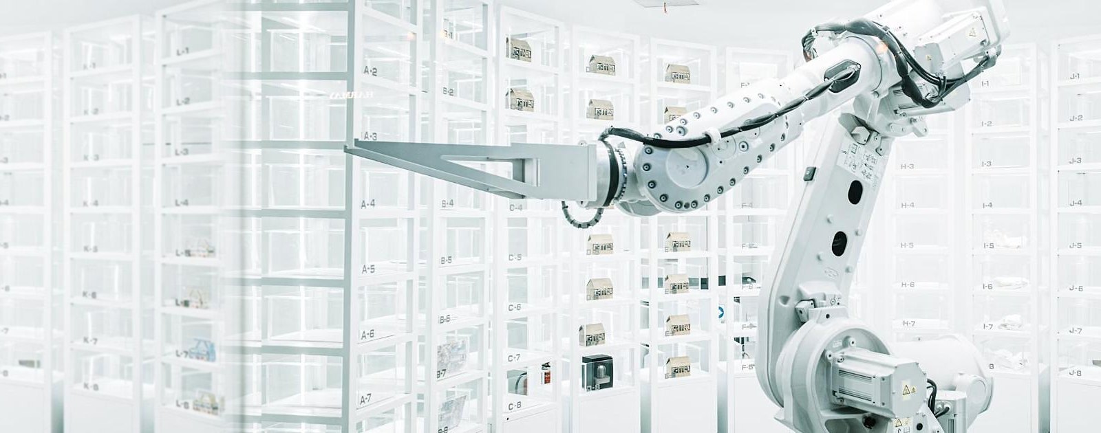 White industrial robot arm in a bright automated storage cell